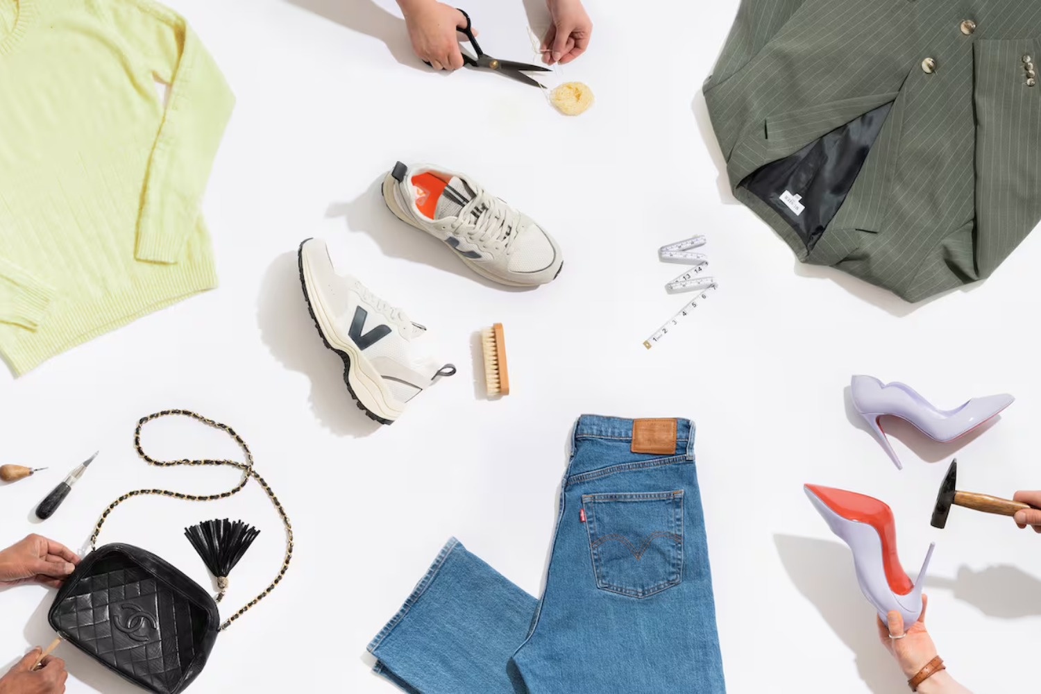 An overhead flat-lay of shoes, clothing, and repair tools, showcasing circular fashion, product longevity, and the importance of extending end-of-life cycles.